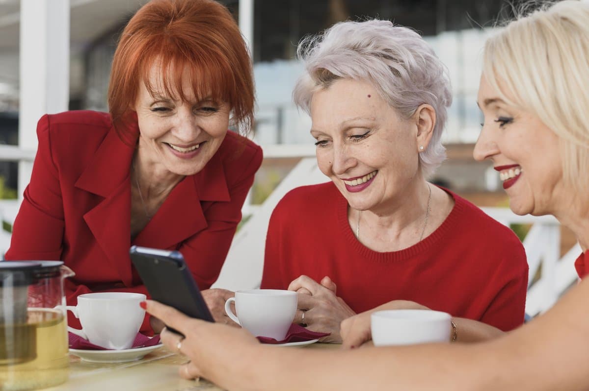 Mujeres mayores felices compartiendo un momento en un café